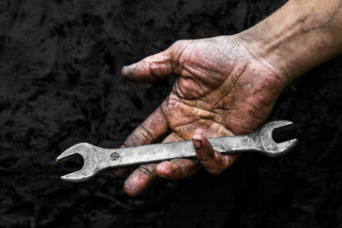 mano-sucia-hombre-trabajador-llave-inglesa-taller-reparacion-automoviles_140289-29